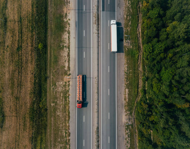 istock Two trucks driving on Highway along the fields. Aerial view landscape 1338749779