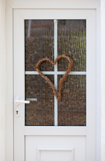 Heart shaped wreath hanging at white door