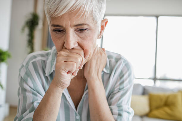 Close up of senior woman coughing Headshot of woman at home, coughing coughing stock pictures, royalty-free photos & images