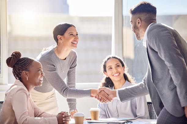 shot of two businesspeople shaking hands during a meeting in an office - win win imagens e fotografias de stock