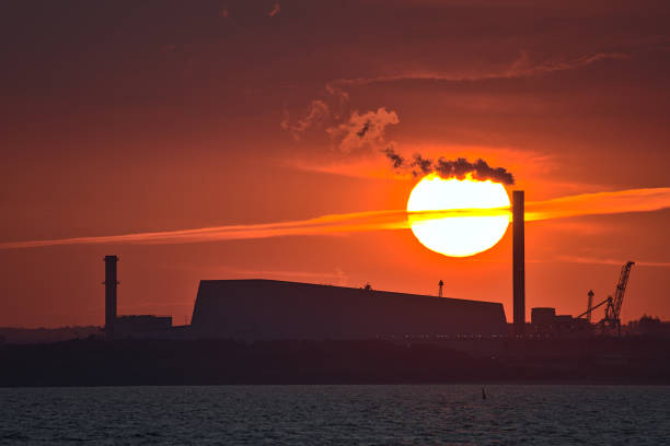 Telephoto view of epic orange sunset over Dublin port and Sun aligned with Covanta Plant (Dublin Waste to Energy) seen from west pier of Dun Laoghaire harbor, Dublin, Ireland stock photo