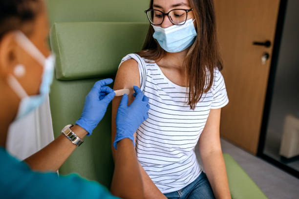 istock Putting band aid on after vaccination 1338754847