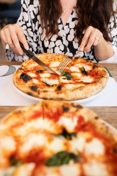 istock Woman eating pizza at cafe 1338755057