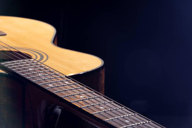 istock Part of acoustic guitar on black background copy space. 1338755243