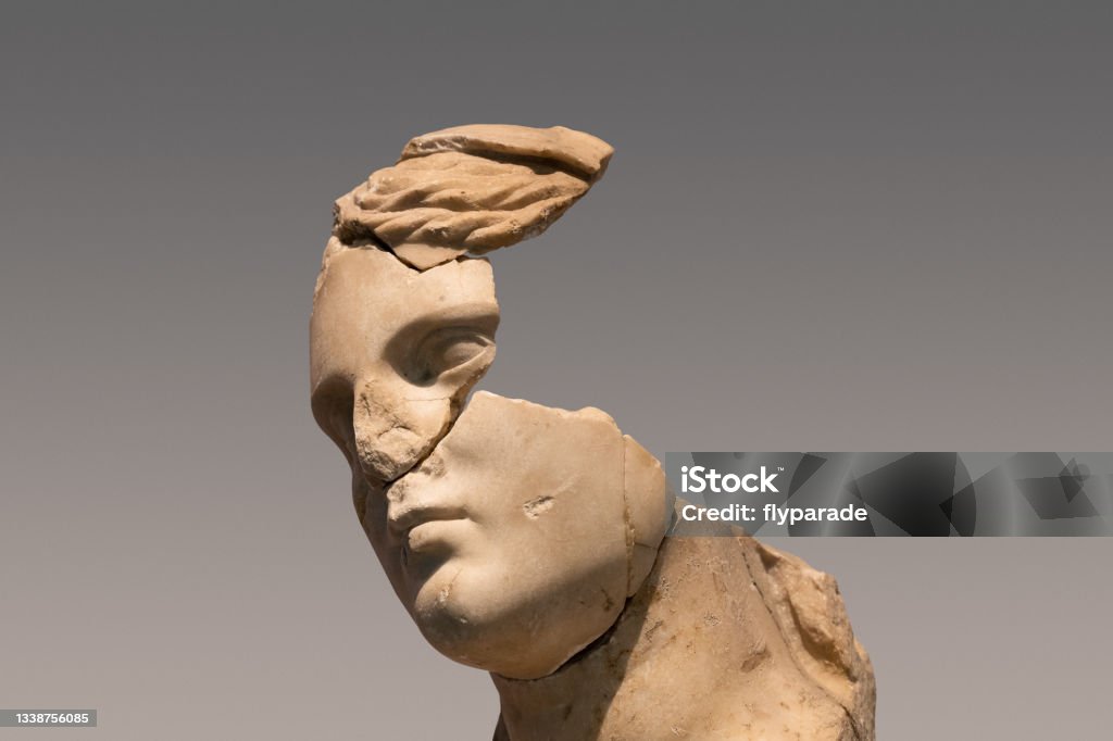 antique woman roman marble statue with large pieces missing closeup portrait of antique damaged stone bust statue depicting a woman head with large pieces missing from the face area and large cracks in the marble Greek Culture Stock Photo