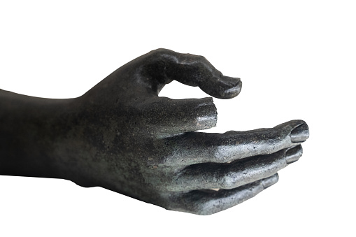 front view closeup of black marble statue hand with broken index finger reaching out isolated on white background
