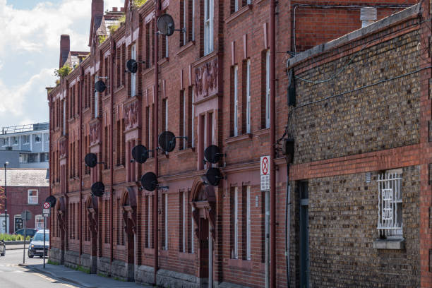 istock Old red bricks building with many satellite dishes on the walls. 1338756933