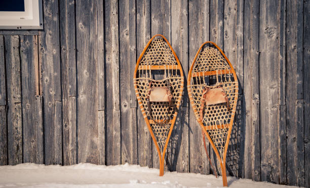 racchette da neve contro un fienile di legno - snowshoeing foto e immagini stock