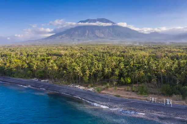 Aerial landscape taken by drone of the northern coastline of Bali in Indonesia with the Mount Agung volcano sitting on the horizon