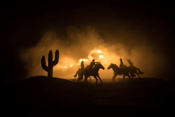 istock Western cowboy silhouette with texture at sunset and slivers of light 1338761531