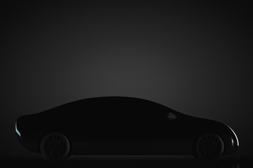 Black unrecognizable passenger car on a dark background.