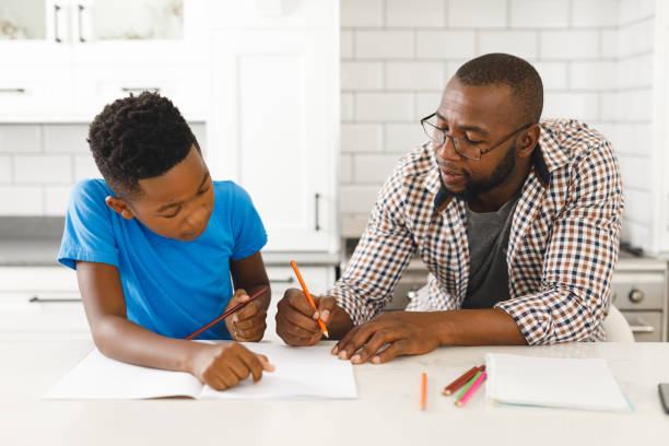 istock African american father and his son in kitchen, doing homework together 1338770601