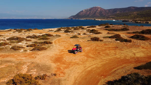vista aérea del coche buggy en la arena en la costa del mar de chipre o griego en verano. viaje extremo fuera de la carretera lugar. aventura al aire libre para turistas - akamas fotografías e imágenes de stock