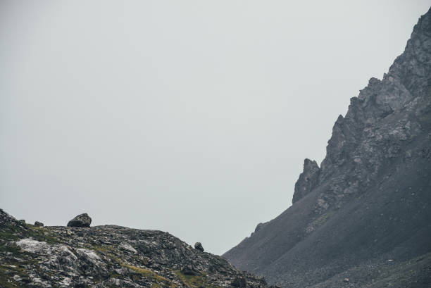 istock Atmospheric highlands landscape with narrow mountain valley and sharp rocks on steep slope under gray sky. Bleak mountain scenery with pointed rockies on mountainside and glen in overcast weather. 1338777099