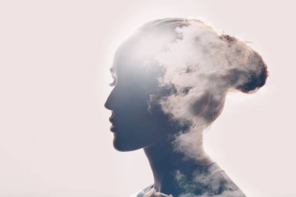 Psychology concept. Sunrise and woman silhouette head Psychology and caucasian woman mental health concept. Multiple exposure clouds and sun on female head silhouette. hysteria stock pictures, royalty-free photos & images