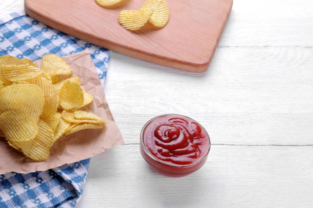 frites, collations et sauce rouge sur une table en bois blanc. aliments malsains - acute pain photos et images de collection