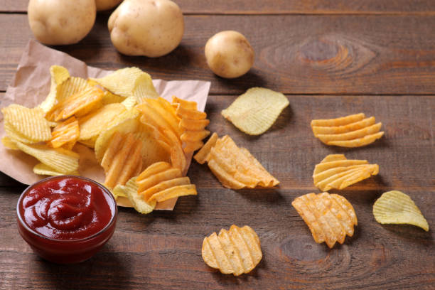 chips avec sauce rouge et pommes de terre fraîches sur une table en bois brun. ingrédients - acute pain photos et images de collection