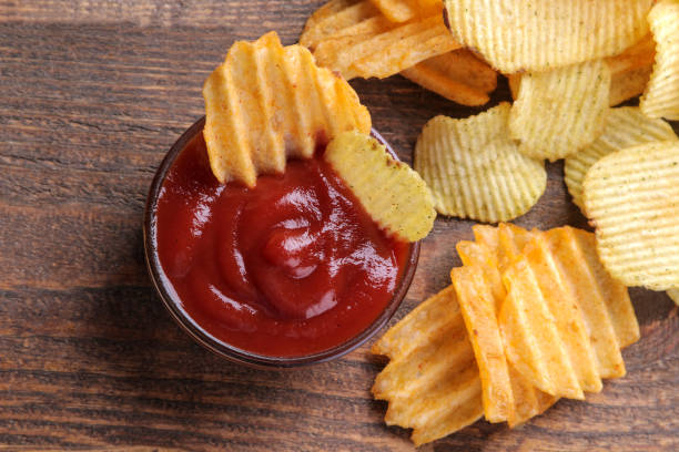 beaucoup de chips différentes avec de la sauce rouge sur une table en bois brun. collations. vue d’en haut - acute pain photos et images de collection