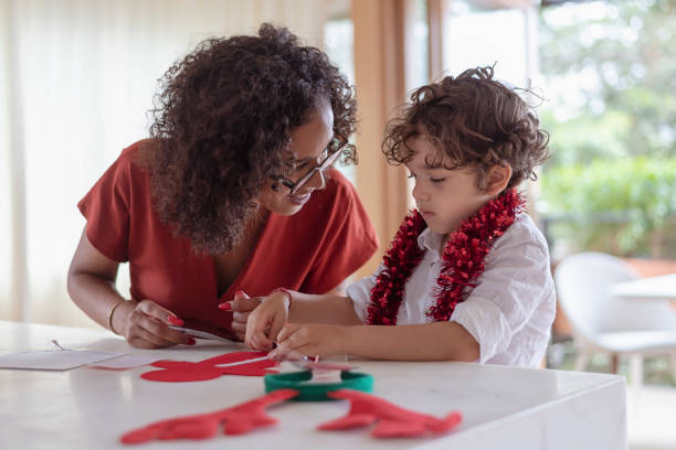 istock Mom helping son with Christmas arts and crafts activity 1338778309