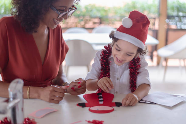 istock Cute little boy doing Christmas themed craft with his mom 1338778322