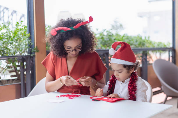 istock Loving mom helps son with Christmas art project 1338778327