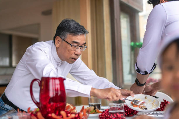 istock Senior man having dinner with family 1338778341