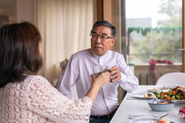 istock Senior couple toasting while enjoying a holiday dinner at home 1338778343