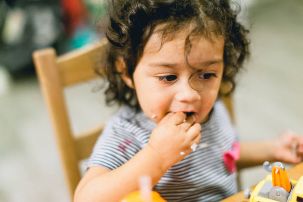 istock Hispanic Little Girl Eating Dinner at the Table 1338782065