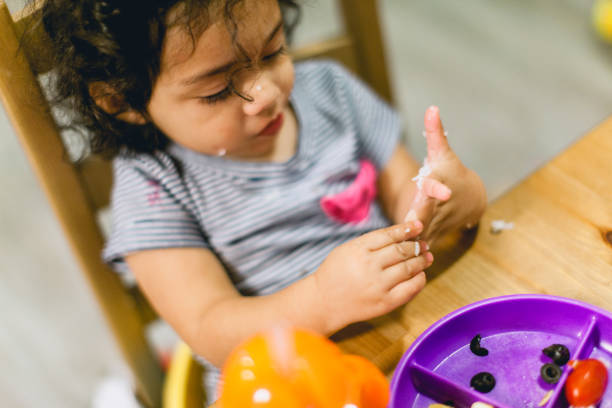 istock Hispanic Little Girl Eating Dinner at the Table 1338782070