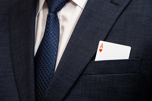 A poker ace card in the pocket of a suit.