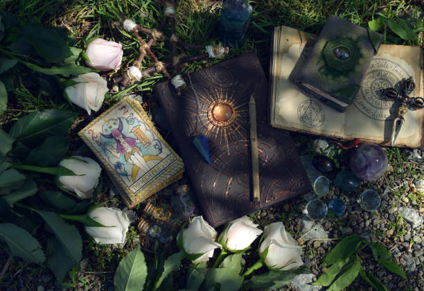 Wicca ritual with beautiful roses, tarot cards, grimoire book and magic objects. stock photo