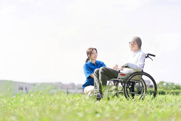 芝生で会話をしている高齢者や介護者 - リタイアメントコミュニティ ストックフォトと画像