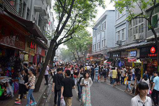 Crowd of people walking on a busy commercial street in central Guangzhou, Guangdong province, China