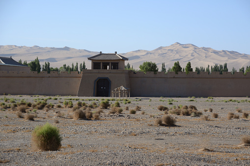 Fortified wall at Movie set with the huge dunes of the Gobi desert, Dunhuang, Gansu province, China