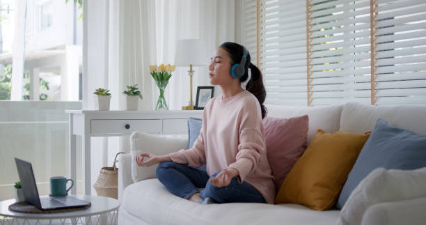 Young asia people teenage girl close eyes sit on sofa couch at home easy asana lotus pose in yoga app zen online class on internet on break time self relax calm, rest mind and mental health life care. jóvenes asiáticos adolescentes ojos cerrados se sientan en el sofá sofá de casa fácil asana lotus pose en yoga aplicación zen clase en línea en internet en el tiempo de descanso autorelajarse calma, descansar mente y salud mental cuidado de la vida.