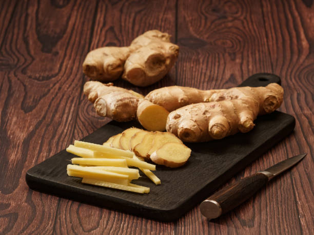 istock Ginger root cut into strips and slices on a burned wood cutting board, shallow focus 1338801287