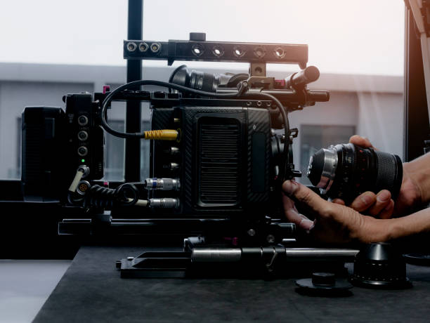 istock Human hand inserting the cinema lens into a movie camera mount. 1338801419