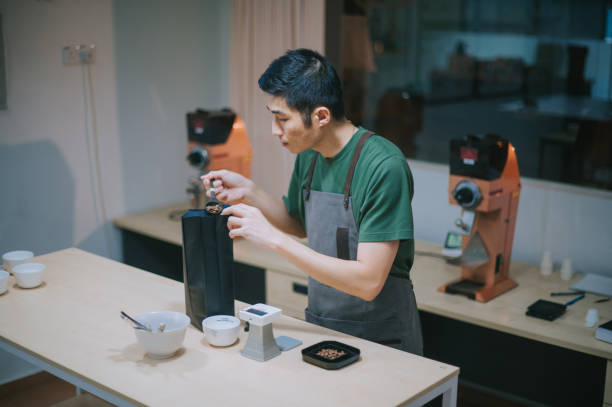 istock professional asian chinese barista preparing coffee cupping getting sample scooping weighing with weigh scale in a bright room 1338803353
