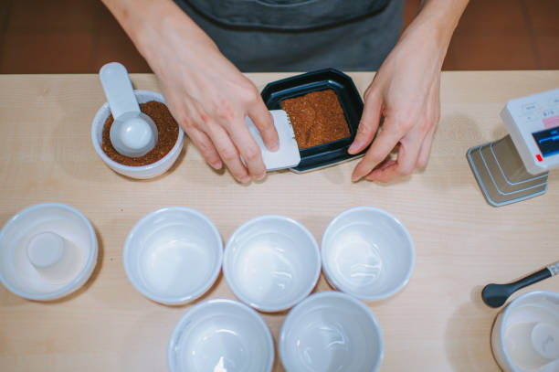 istock close up professional asian chinese barista preparing coffee cupping getting sample scooping weighing with weigh scale in a bright room 1338803371