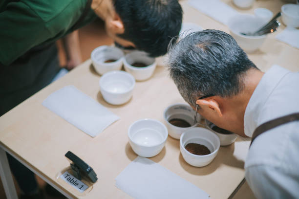 Cup Taster Tasting Degustation Coffee Quality Test. Coffee Samples CuppingProfessional grader inspecting the quality of coffee and skim off the coffee grounds from ceramic cup on the table