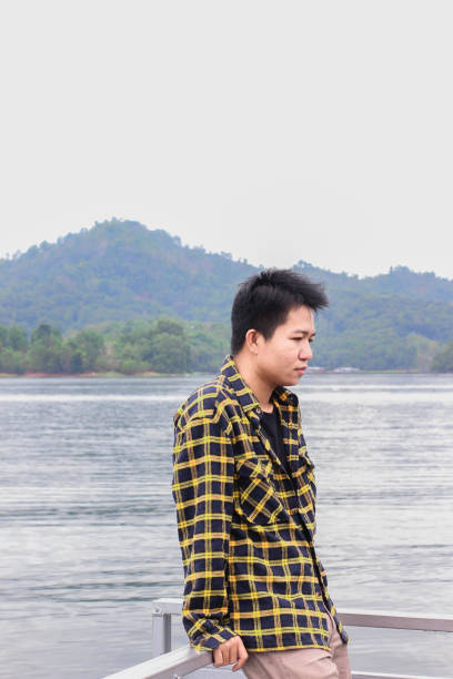 istock young man relaxing by the lake 1338804208