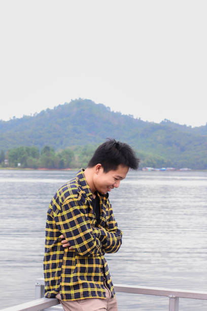 istock young man relaxing by the lake 1338804264