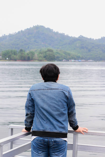 istock young man relaxing by the lake 1338804311