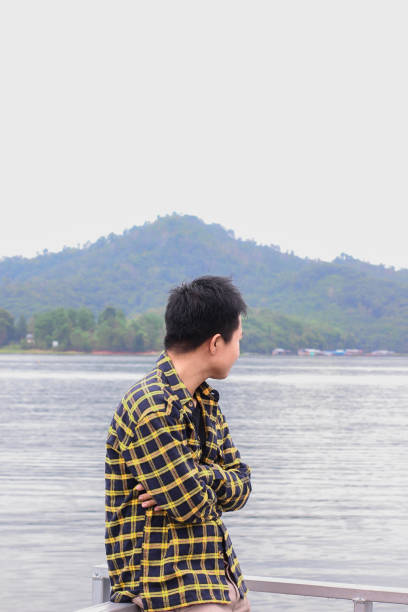 istock young man relaxing by the lake 1338804312