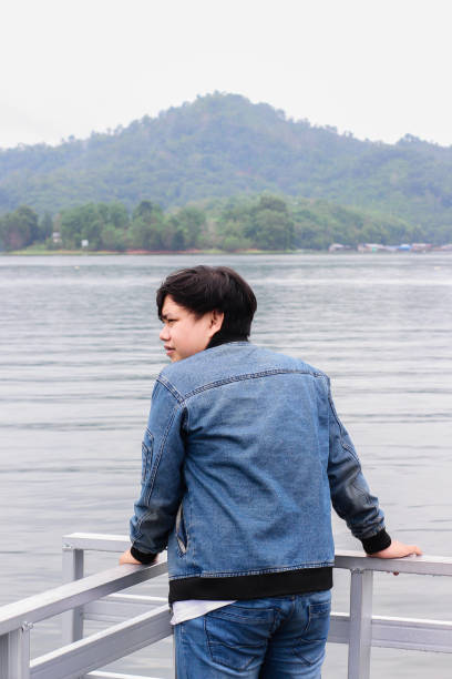 istock young man relaxing by the lake 1338804313