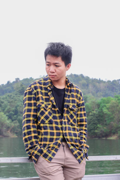 istock young asian man relaxing by the lake 1338804483