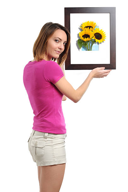 istock Young Woman Hanging Frame with Sunflowers on White 133880458