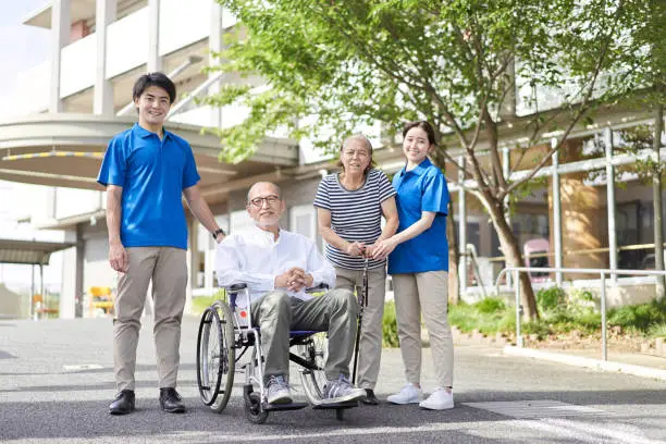 Photo of Wheelchair-riding elderly and caregivers