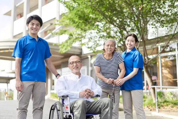 Photo of Wheelchair-riding elderly and caregivers