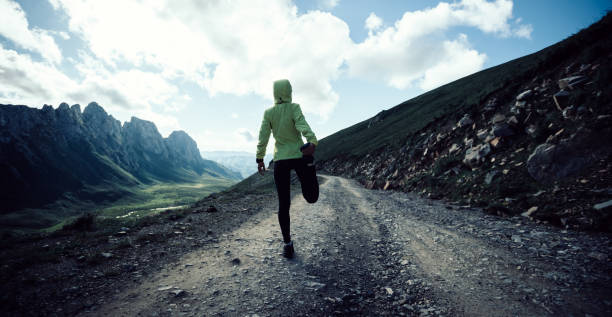 istock Woman ultramarathon runner stretching legs while running at mountain top 1338806142